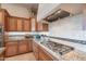 Gourmet kitchen with custom cabinetry, granite countertops, and a professional-grade cooktop at 706 E La Palta St, Queen Creek, AZ 85140