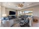 This living room features a ceiling fan, recessed lights, a large window, and a leather sofa at 706 E La Palta St, Queen Creek, AZ 85140