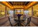 Covered outdoor patio with dining table, chairs, string lights, and kitchen view through sliding glass doors at 706 E La Palta St, Queen Creek, AZ 85140