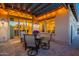 Cozy covered patio with a dining table, string lights, and a view into the brightly lit interior through sliding glass doors at 706 E La Palta St, Queen Creek, AZ 85140