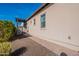 Landscaped side yard with gravel, brick paver walkway, pergola, and desert plants under a blue sky at 706 E La Palta St, Queen Creek, AZ 85140