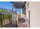 View of a brick paver path leading to a pergola-covered area, framed by an iron fence and desert landscaping at 706 E La Palta St, Queen Creek, AZ 85140