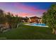 Stunning backyard featuring a sparkling pool, lush green lawn, and covered patio perfect for outdoor entertaining at 8845 E Sierra Pinta Dr, Scottsdale, AZ 85255