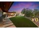 Expansive backyard with patio seating, lawn, pool, and desert landscaping at 8845 E Sierra Pinta Dr, Scottsdale, AZ 85255