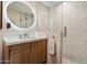 Sleek bathroom featuring a wood vanity and a walk-in shower with stone mosaic tile at 8845 E Sierra Pinta Dr, Scottsdale, AZ 85255