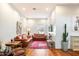 Cozy living room with hardwood floors, brick-red couches, colorful rug, and ample natural light at 8845 E Sierra Pinta Dr, Scottsdale, AZ 85255