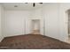 Open bedroom features a ceiling fan, plush carpet, and an en suite bathroom at 8962 W Grovers Ave, Peoria, AZ 85382
