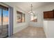 Bright breakfast nook features neutral tile flooring, a modern light fixture, and large windows offering ample natural light at 8962 W Grovers Ave, Peoria, AZ 85382