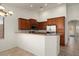 Well-lit kitchen featuring wooden cabinets, granite countertops, stainless steel appliances, and breakfast bar seating at 8962 W Grovers Ave, Peoria, AZ 85382