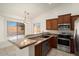 Stylish kitchen with wooden cabinets, granite countertops, stainless-steel appliances, and adjacent dining area at 8962 W Grovers Ave, Peoria, AZ 85382