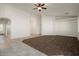 Inviting open-concept living room blending carpet and tiled flooring, with neutral walls and modern ceiling fan at 8962 W Grovers Ave, Peoria, AZ 85382