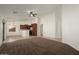 Open floor plan with carpeted living area flowing into a tiled kitchen, complete with breakfast bar and stainless-steel appliances at 8962 W Grovers Ave, Peoria, AZ 85382