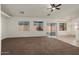 Spacious carpeted living room with large windows and sliding glass doors, offering ample natural light at 8962 W Grovers Ave, Peoria, AZ 85382