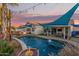 Beautiful backyard with a pool, outdoor kitchen and patio dining area with string lights at 950 W Cooley Dr, Gilbert, AZ 85233