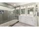 This bathroom includes a dual sink vanity and glass shower featuring a pebble floor at 950 W Cooley Dr, Gilbert, AZ 85233