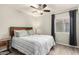 This bedroom features wood floors, a ceiling fan, and a large window for natural light at 950 W Cooley Dr, Gilbert, AZ 85233