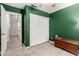 This bedroom showcases light wood floors, green walls, and an attached walk-in closet at 950 W Cooley Dr, Gilbert, AZ 85233