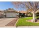 Charming home features a well-manicured lawn, desert landscaping, and a two-car garage at 950 W Cooley Dr, Gilbert, AZ 85233