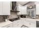 The kitchen features white cabinets, stainless steel appliances, and mosaic tile backsplash at 950 W Cooley Dr, Gilbert, AZ 85233
