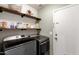 Convenient laundry room with open shelving above the front-load washer and dryer at 950 W Cooley Dr, Gilbert, AZ 85233
