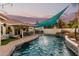 Backyard pool with waterfall features, outdoor kitchen, and covered patio at 950 W Cooley Dr, Gilbert, AZ 85233