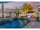Inviting pool area with a fire feature, rock waterfall, and shade sails at 950 W Cooley Dr, Gilbert, AZ 85233
