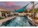 Backyard pool featuring waterfall features, outdoor dining area, and sun shades at 950 W Cooley Dr, Gilbert, AZ 85233