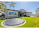 Backyard with an inset trampoline, artificial turf, patio and covered area at 9960 E Strobe Ave, Mesa, AZ 85212