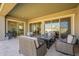Covered outdoor patio featuring cushioned seating, a fireplace and view into the backyard at 9960 E Strobe Ave, Mesa, AZ 85212