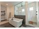 Bright bathroom featuring a modern tub and a glass-enclosed shower, and a walk in closet at 9960 E Strobe Ave, Mesa, AZ 85212