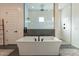 Modern bathroom with a freestanding tub and a glass-enclosed shower with white subway tile at 9960 E Strobe Ave, Mesa, AZ 85212
