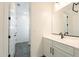 A stylish bathroom with modern lighting fixtures, a white vanity, and a neutral color palette for a soothing ambiance at 9960 E Strobe Ave, Mesa, AZ 85212