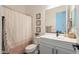 Well-lit bathroom featuring a shower and tub, clean white cabinets, and sleek fixtures at 9960 E Strobe Ave, Mesa, AZ 85212
