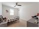 Bright bedroom featuring a ceiling fan, a sports-themed poster, and neutral tones for a relaxed ambiance at 9960 E Strobe Ave, Mesa, AZ 85212