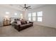 Bright bedroom featuring a sitting area with a leather couch, a ceiling fan, and abundant natural light at 9960 E Strobe Ave, Mesa, AZ 85212