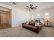 Spacious bedroom featuring a leather couch and a view of the home's hallway at 9960 E Strobe Ave, Mesa, AZ 85212