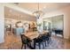 Open concept dining room featuring a wooden table, modern chandelier, and access to the kitchen at 9960 E Strobe Ave, Mesa, AZ 85212
