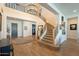 Elegant foyer featuring a staircase, hardwood floors, and an arched front entry door at 9960 E Strobe Ave, Mesa, AZ 85212