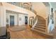 Elegant foyer featuring a staircase, hardwood floors, and an arched front entry door at 9960 E Strobe Ave, Mesa, AZ 85212