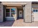 Inviting front porch with brick accents, supporting columns, and a charming wreath on the entrance door at 9960 E Strobe Ave, Mesa, AZ 85212