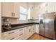 Bright kitchen showcasing white cabinets, stainless steel refrigerator, and black countertops at 9960 E Strobe Ave, Mesa, AZ 85212