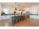 Open kitchen featuring a large island with seating, stainless appliances, and bright white cabinetry at 9960 E Strobe Ave, Mesa, AZ 85212