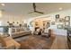 Open-concept living room with comfortable seating, a ceiling fan, and a gallery wall at 9960 E Strobe Ave, Mesa, AZ 85212