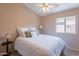 Well-lit carpeted bedroom featuring ceiling fan, side tables, lamps and a window with a view of the outside at 10368 E Gold Nugget Ct, Gold Canyon, AZ 85118
