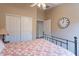A cozy bedroom features a floral comforter and a unique decorative clock on the wall at 10368 E Gold Nugget Ct, Gold Canyon, AZ 85118