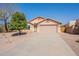 Tan single-story home with a two-car garage and low maintenance desert landscaping and a concrete driveway at 10368 E Gold Nugget Ct, Gold Canyon, AZ 85118