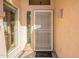 A beautiful front door with a screen door, sidelight window, and stylish lighting fixture at 10368 E Gold Nugget Ct, Gold Canyon, AZ 85118