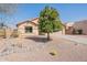 A single-story home with desert landscaping including river rock, barrel cactus, and a green shade tree at 10368 E Gold Nugget Ct, Gold Canyon, AZ 85118