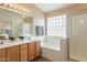 Bright bathroom with double sinks, tub with glass block window and walk-in shower with glass doors at 10368 E Gold Nugget Ct, Gold Canyon, AZ 85118
