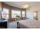 Bright main bedroom featuring carpet, ceiling fan, large windows and a door to the main bathroom at 10368 E Gold Nugget Ct, Gold Canyon, AZ 85118